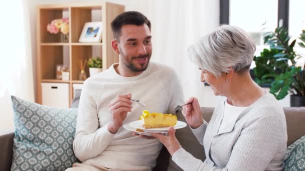 Madre mayor e hijo adulto comiendo pastel en casa — Vídeos de Stock