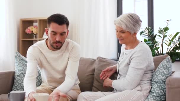 Erwachsener Sohn und Mutter trinken Kaffee zu Hause — Stockvideo