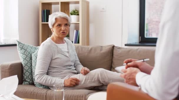 Psychologist giving glass of water to senior woman — Stock Video