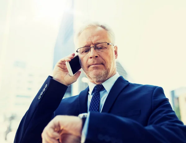 Senior zakenman belt op smartphone in de stad — Stockfoto