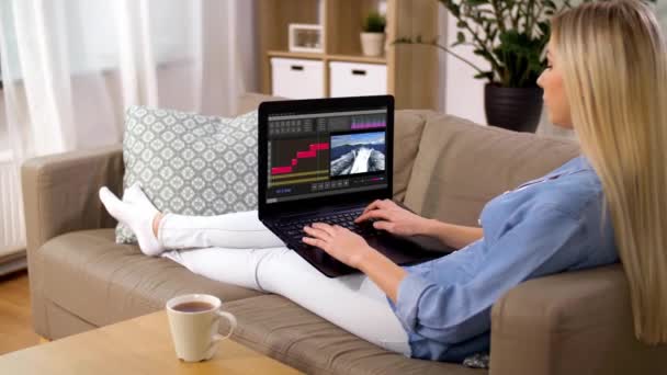 Vrouw met video-editor programma op laptop thuis — Stockvideo