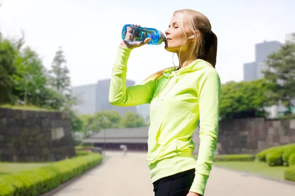 Mujer beber agua después de hacer ejercicio en el parque de la ciudad —  Fotos de Stock