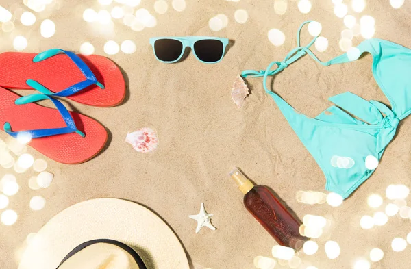 Chapeau de paille, tongs et lunettes de soleil sur sable de plage — Photo