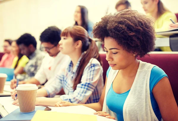 Group of students with coffee writing on lecture — Stock Photo, Image