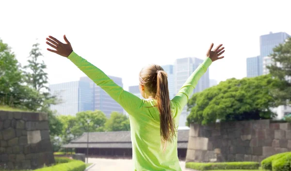 Mujer feliz en ropa deportiva en el parque de la ciudad de Tokyo —  Fotos de Stock