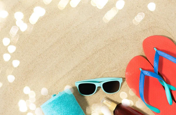 Chapeau de paille, tongs et lunettes de soleil sur sable de plage — Photo