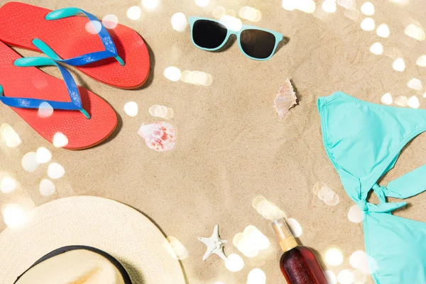 Chapeau de paille, tongs et lunettes de soleil sur sable de plage — Photo