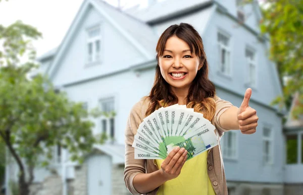 Aziatische vrouw met euro geld tonen duimen omhoog — Stockfoto