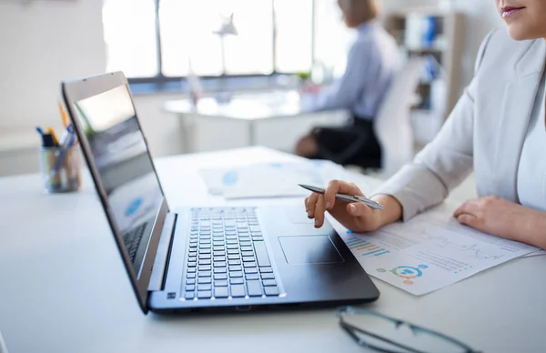 Mujer de negocios con portátil trabajando en la oficina Fotos de stock