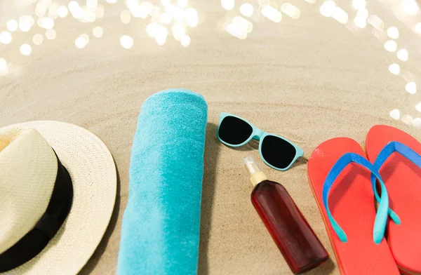 Chapeau de paille, tongs et lunettes de soleil sur sable de plage — Photo