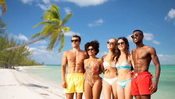 Amici felici in costume da bagno che si abbracciano sulla spiaggia estiva — Foto Stock