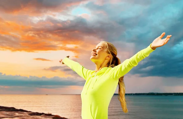 Gelukkige vrouw in sportkleding aan zee — Stockfoto