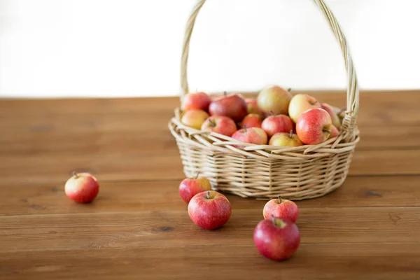 Tahta masada hasır sepetin içinde olgun elmalar — Stok fotoğraf
