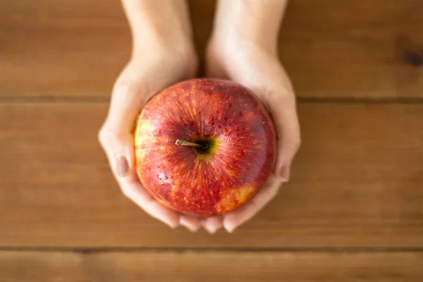 Gros plan des mains tenant la pomme rouge mûre — Photo