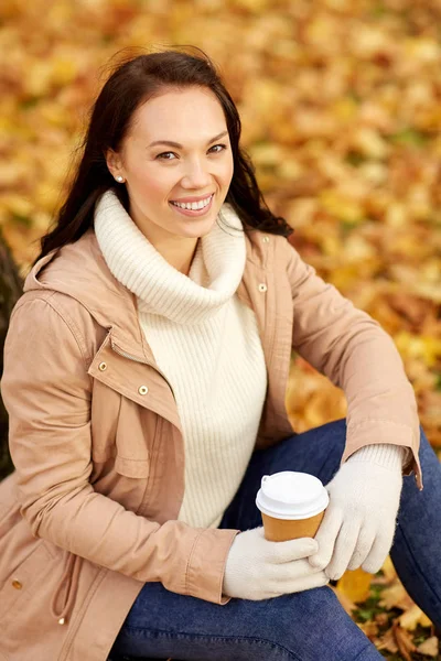 Kvinna dricka hämtmat kaffe i höstparken — Stockfoto