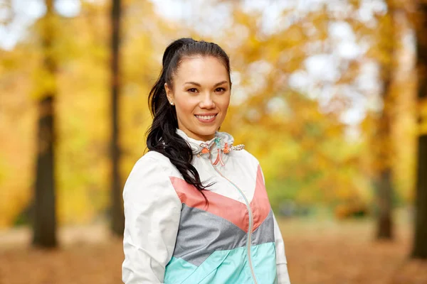 Giovane donna in abbigliamento sportivo al parco autunnale — Foto Stock