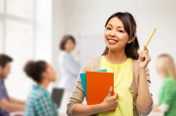 Asian student woman with books and pencil — Stock Photo, Image