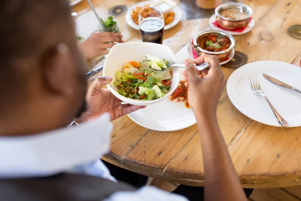 Africano america hombre comer ensalada en restaurante —  Fotos de Stock