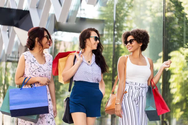 Gelukkig vrouwen met boodschappentassen wandelen in de stad — Stockfoto