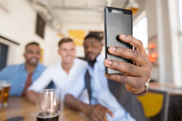 Amigos tomando selfie e beber cerveja no bar — Fotografia de Stock