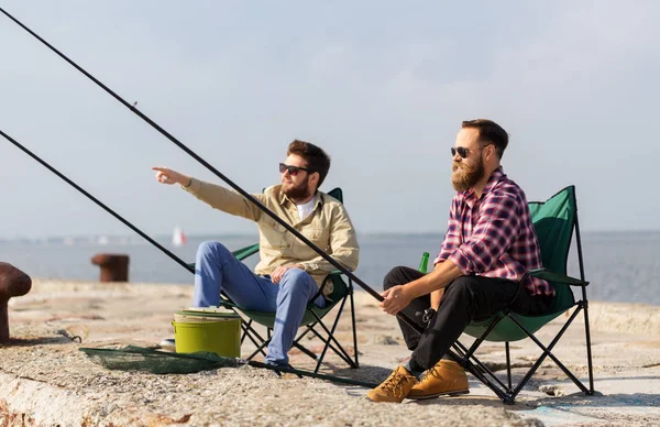 Amigos do sexo masculino com varas de pesca no cais — Fotografia de Stock