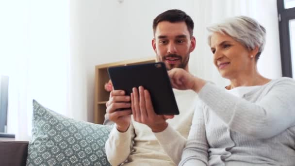 Alte Mutter und erwachsener Sohn mit Tablet-PC zu Hause — Stockvideo