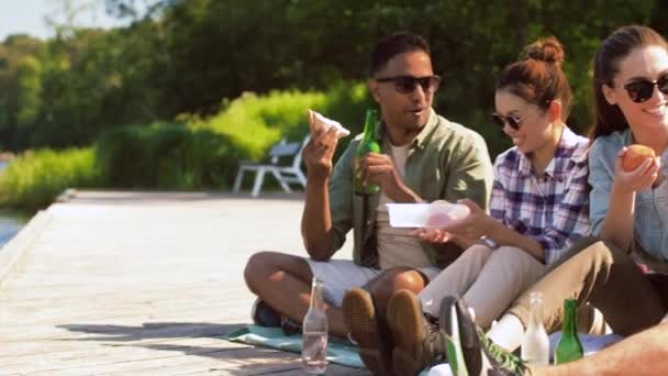 Přátelé pěší turistiku a piknik na jezeře molo — Stock video