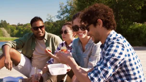 Vänner som har picknick på piren vid sjön eller floden — Stockvideo