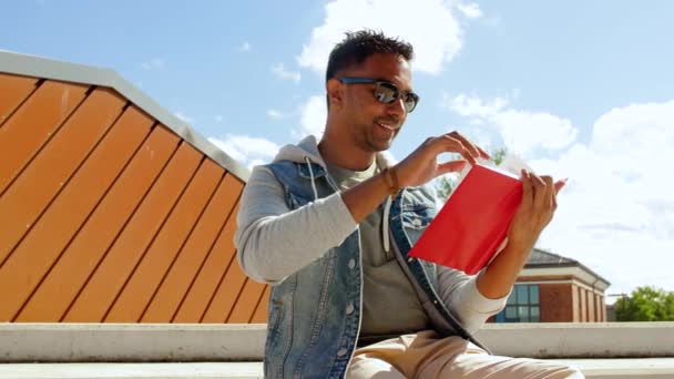 Man läser bok och dricker kaffe på taket — Stockvideo