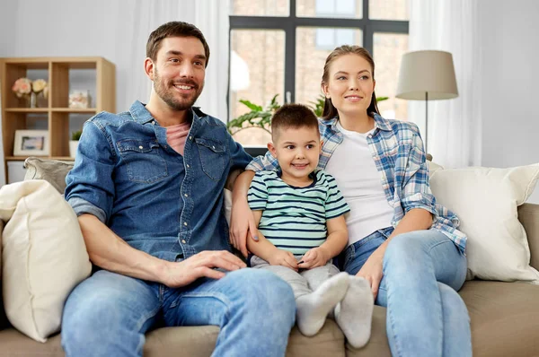 Retrato de la familia feliz sentado en el sofá en casa —  Fotos de Stock