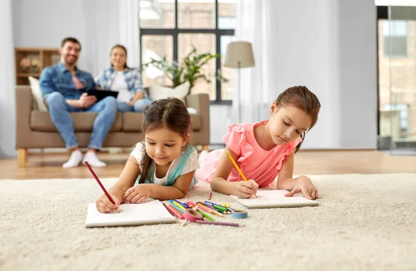 Hermanas felices dibujando en cuadernos de dibujo en casa Imagen De Stock