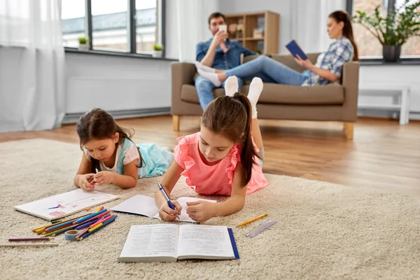 Щасливі сестри малюють і роблять домашнє завдання вдома — стокове фото