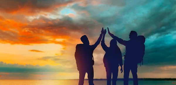 Travellers making high five over sunset — Stock Photo, Image