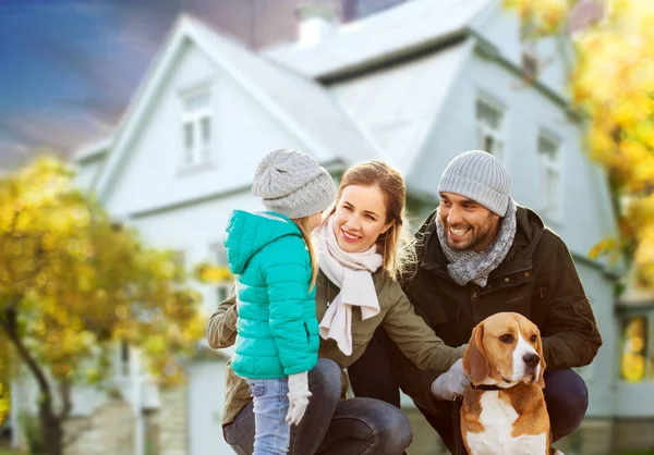 Happy family with dog over house in autumn — Stock Photo, Image