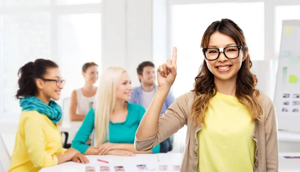 Asiatisk kvinna i glasögon eller student med finger upp — Stockfoto