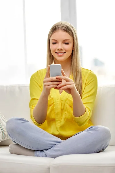 Jong vrouw of tiener meisje met smartphone thuis — Stockfoto