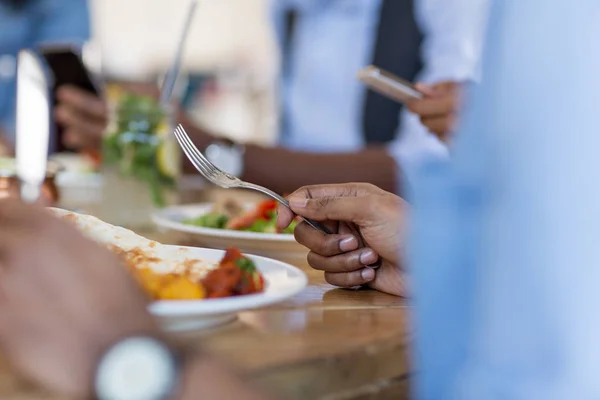 Hombre africano comiendo con amigos en el restaurante —  Fotos de Stock