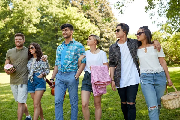 Amigos con guitarra y manta de picnic en el parque — Foto de Stock