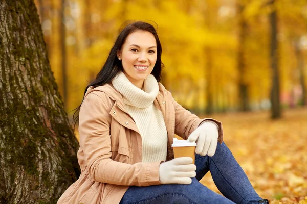 Kvinna dricka hämtmat kaffe i höstparken — Stockfoto