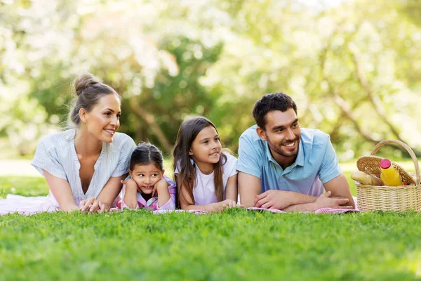 Familia que pone en manta de picnic en el parque de verano —  Fotos de Stock