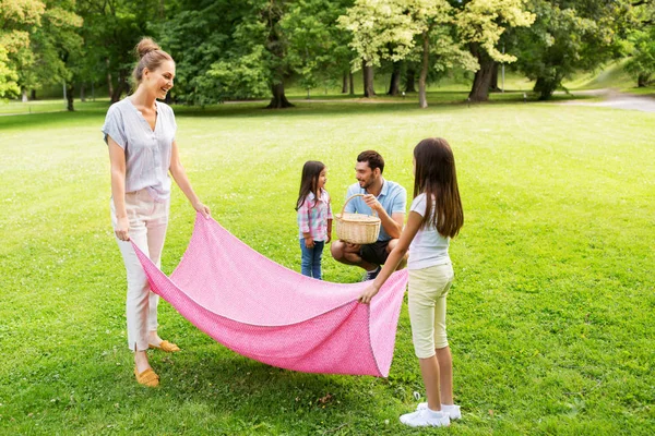 Familj lägger ner picknick filt i sommarparken — Stockfoto