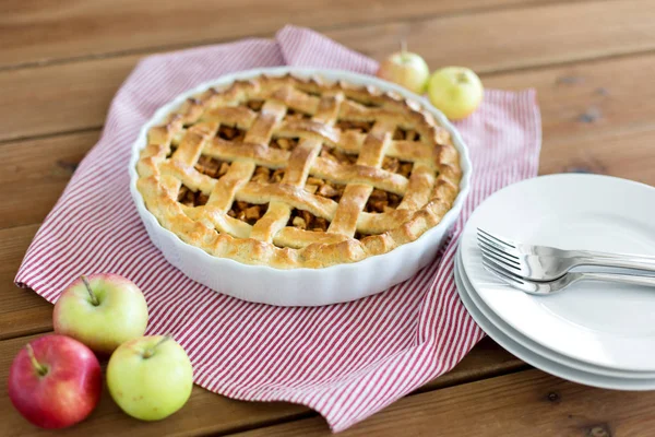 Tarte aux pommes dans un moule de cuisson sur une table en bois — Photo