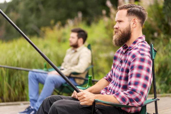 Male friends with fishing rods on lake — Stock Photo, Image