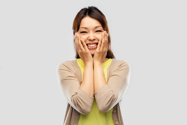 Gelukkig verbaasd aziatische vrouw over grijs achtergrond — Stockfoto