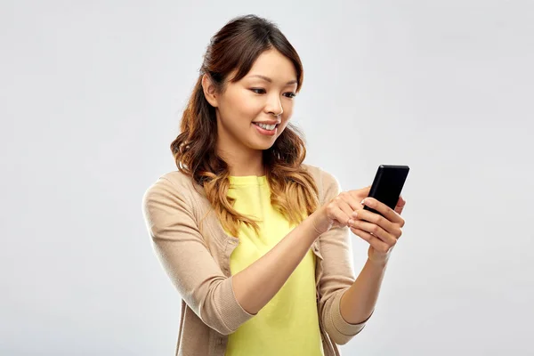 Gelukkig aziatische vrouw met behulp van smartphone — Stockfoto