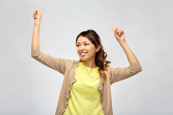 Gri arka planda dans eden mutlu Asyalı kadın — Stok fotoğraf
