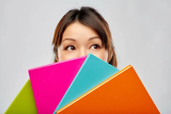 Asiática mulher ou estudante escondendo atrás de cadernos — Fotografia de Stock
