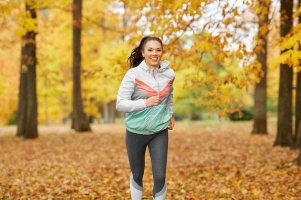 Mujer joven corriendo en el parque de otoño — Foto de Stock