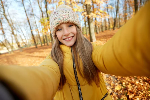 Felice ragazza prendendo selfie al parco autunnale — Foto Stock