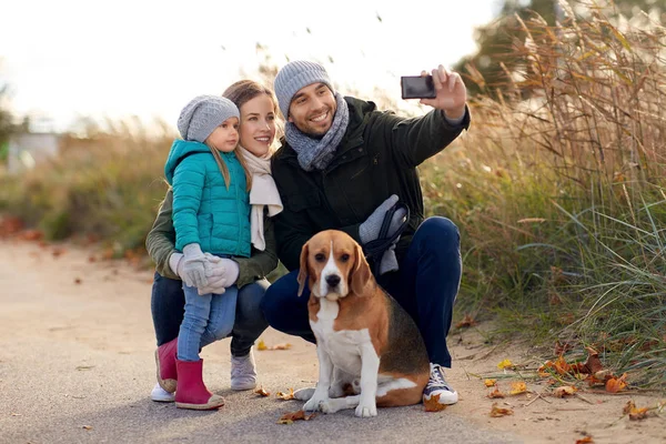 Lycklig familj med hund tar selfie i höst — Stockfoto